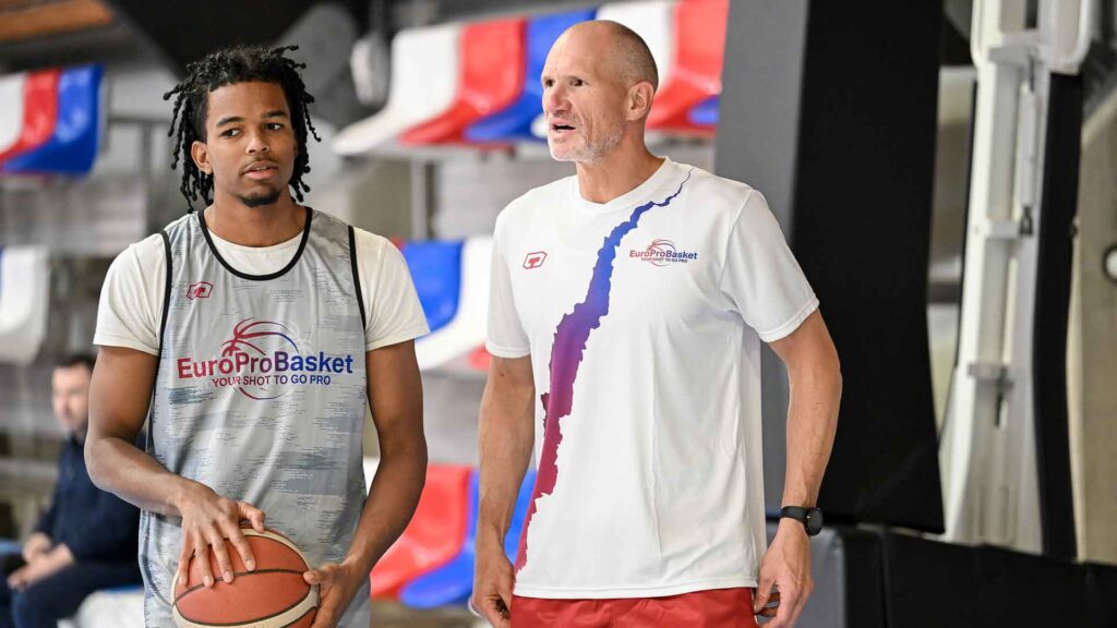 Professional basketball players training at a competitive German league facility where athletes compete for roster spots.